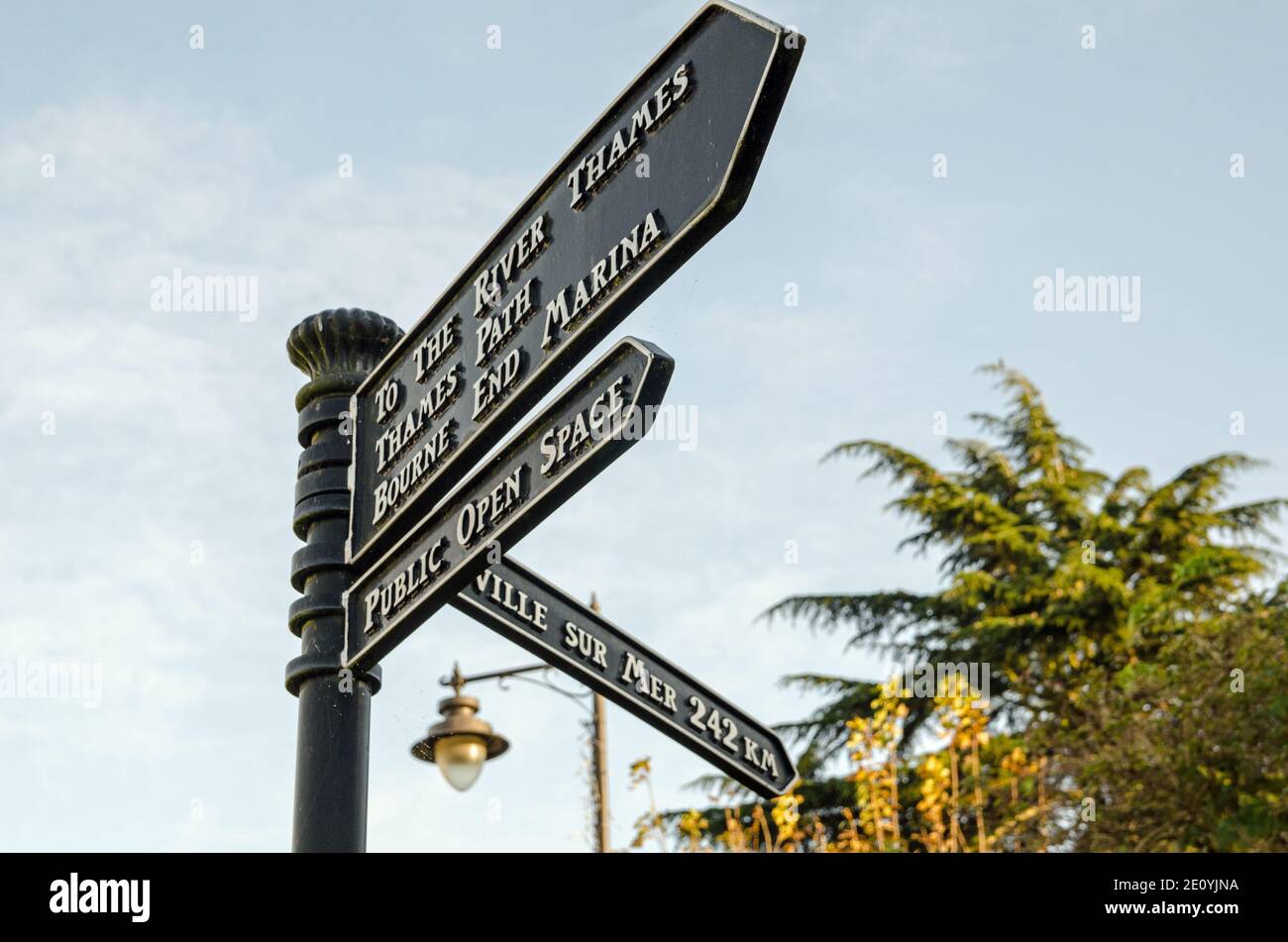 Finger post sign post in the middle of Bourne End, Buckinghamshire with directions to the River Thames and to the twinned French town of Ville Sur Mer Stock Photo