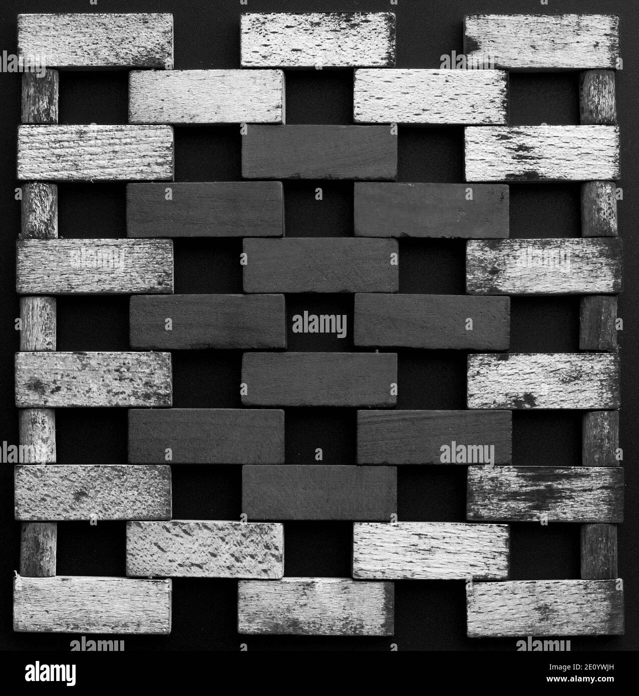 Wall made of small wooden bricks. Black and white wooden blocks