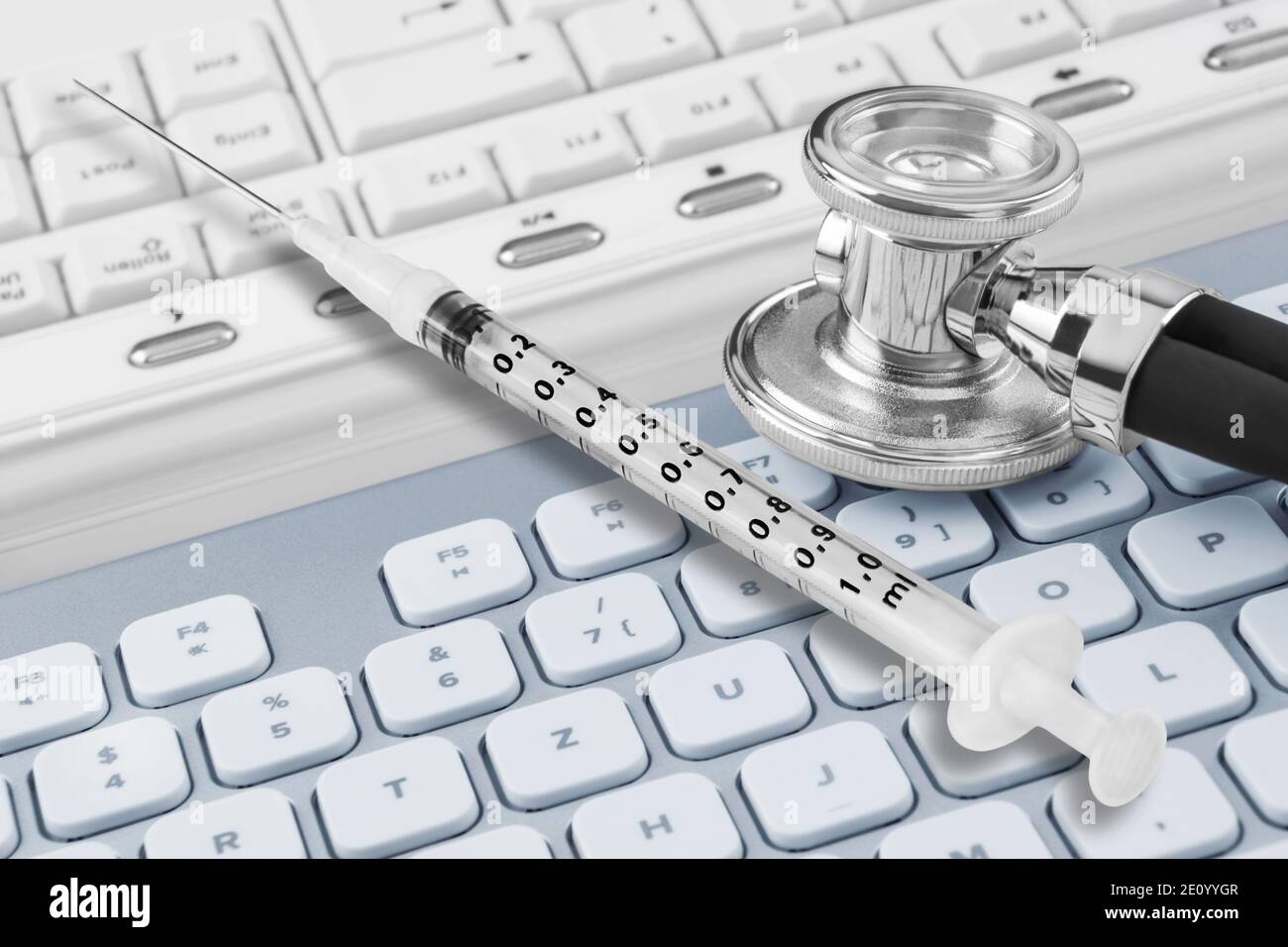 Injection and stethoscope against PC keyboard Stock Photo