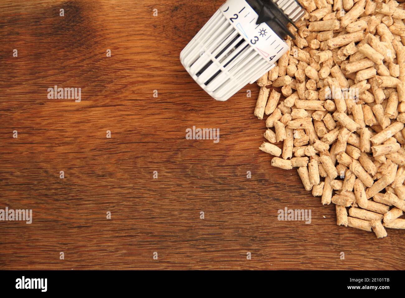 an old oak board with wood pellets and a radiator thermostat Stock Photo Alamy