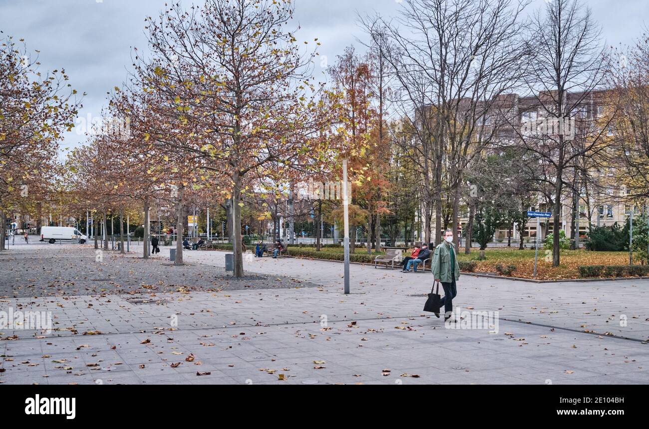 A man walks alone on a square, his face is protected with a mask, Dresden, Germany - 11.17.2020 Stock Photo
