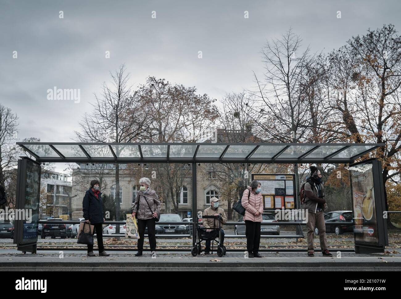 People waiting at a bus station, face coverd with a mask, Dresden, Germany - 11.17.2020 Stock Photo