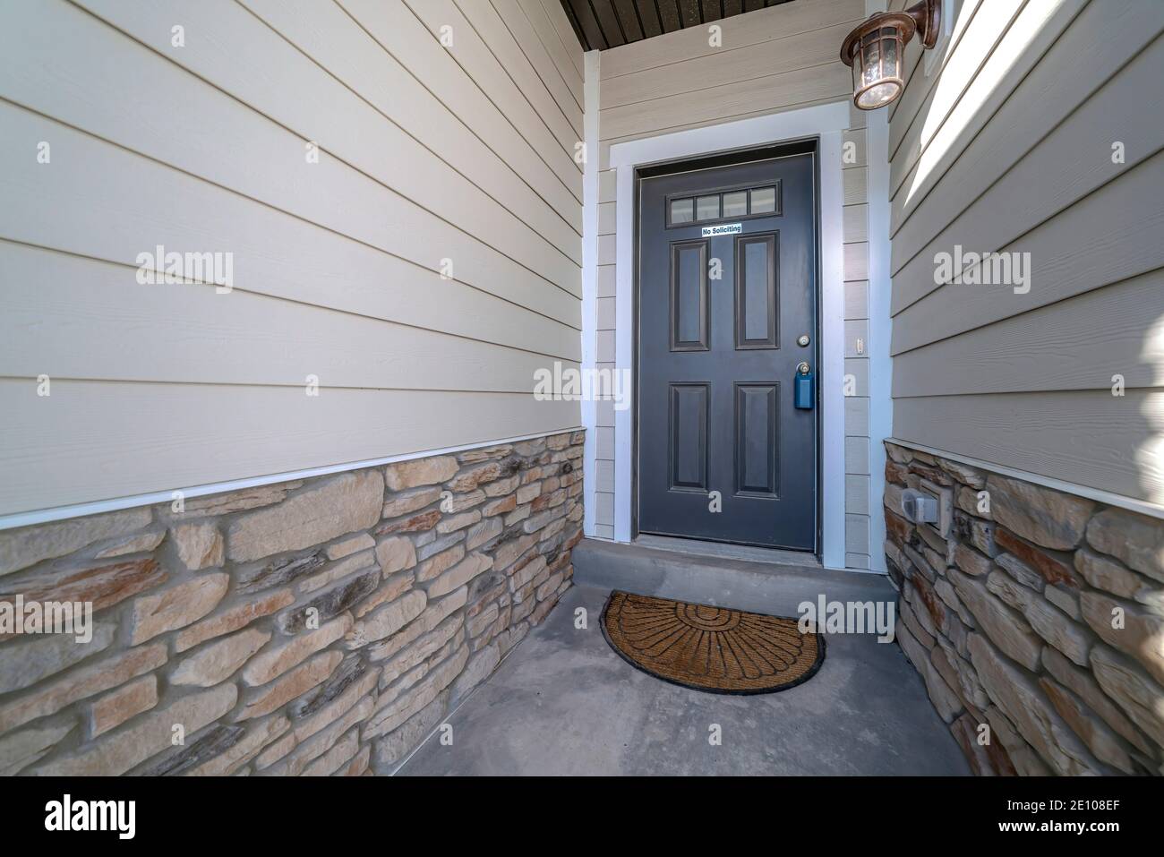 Gray hinged front door with small glass panes at the entrance of