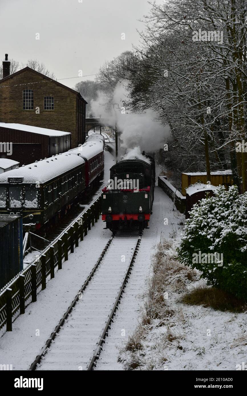 Steam train approaching Haworth station on the KWVR in the snow Stock Photo Alamy
