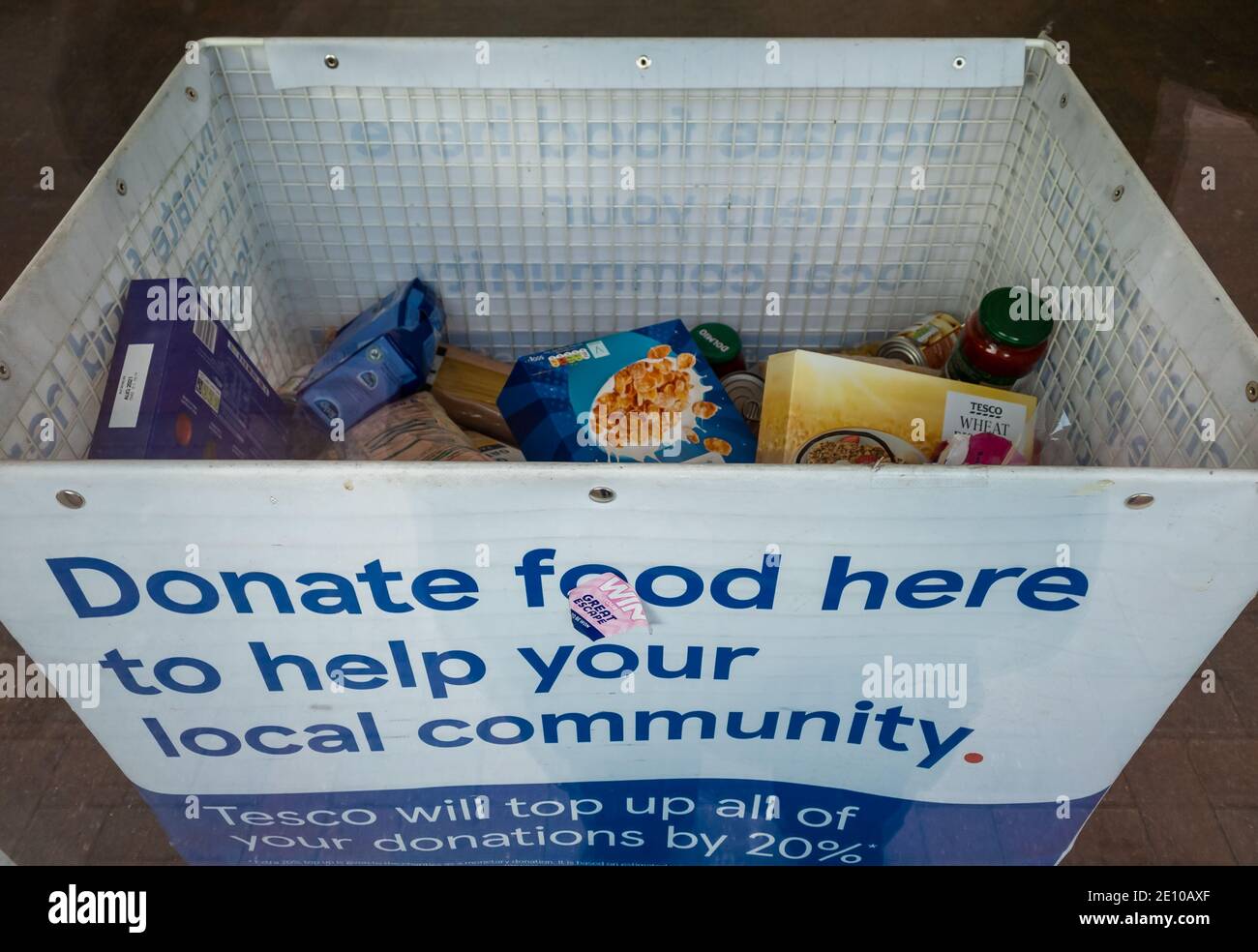 A container by the exit of a supermarket for people to donate food for the poor and needy. Stock Photo