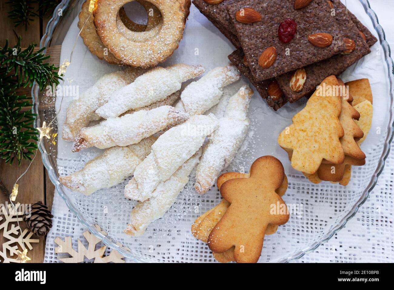 Assorted cookies, fir branches and a garland on a light background. Stock Photo