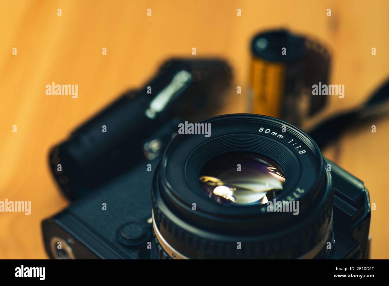 Still life image of an analog camera with some 35mm negative film  on a wooden background. Stock Photo