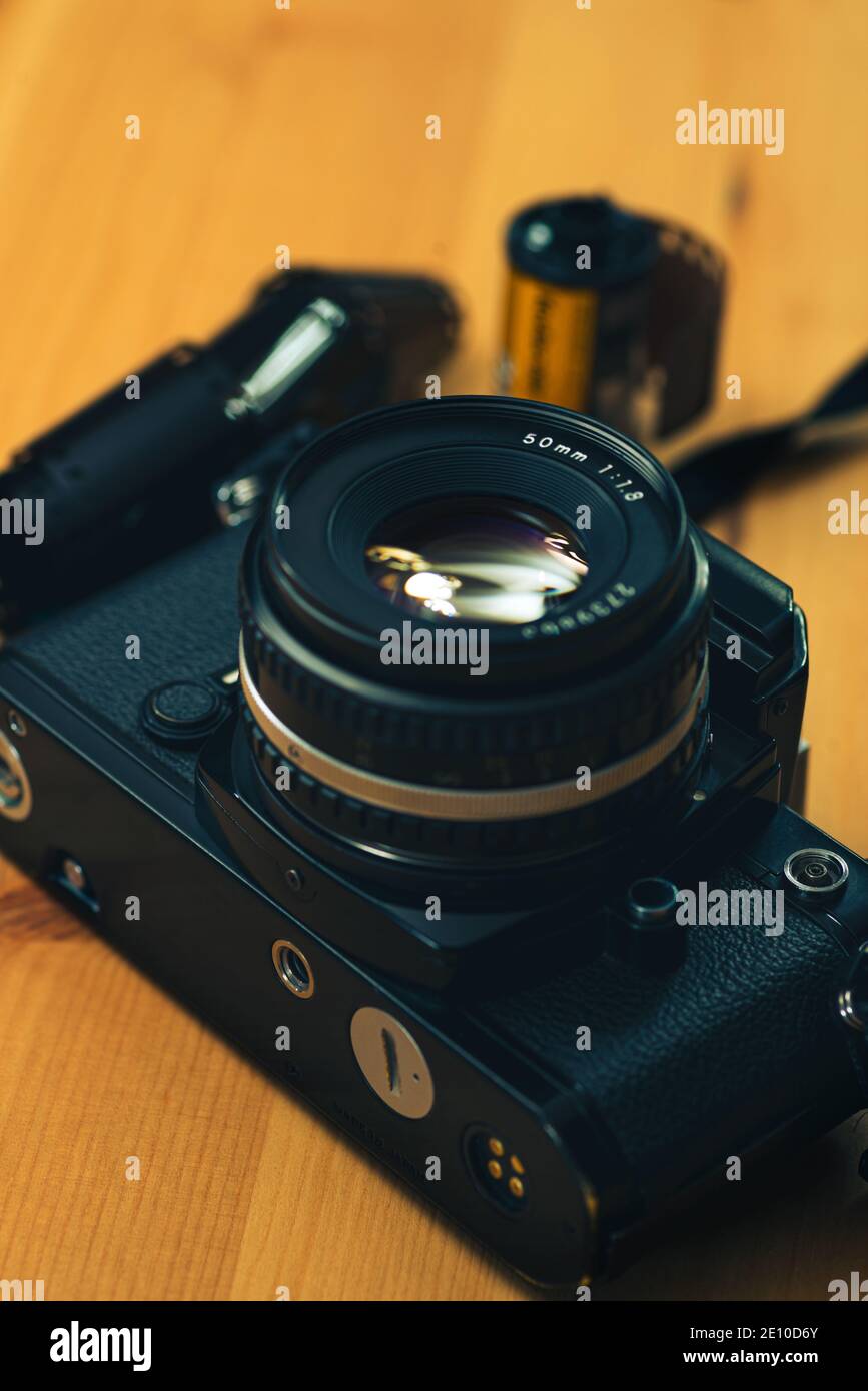 Still life image of an analog camera with some 35mm negative film  on a wooden background. Stock Photo