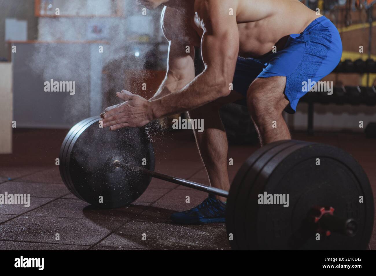 Cropped shot of male crossfit athlete using magnesium, clapping hands  before lifting heavy barbell. Unrecognizable shirtless muscular man  chalking han Stock Photo - Alamy
