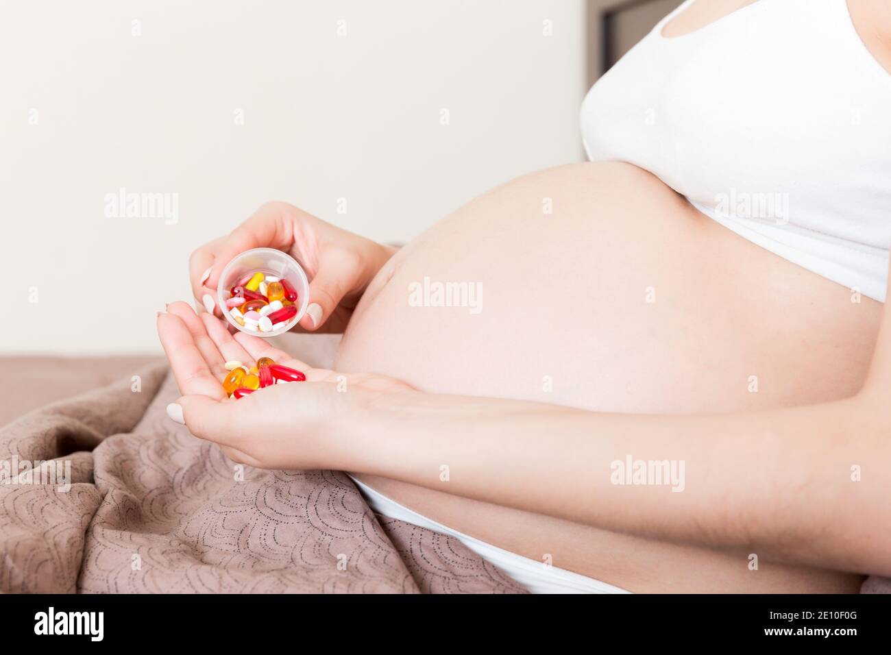 woman hand holding pills for improve of iron level in blood. Receiving vitamins in pregnancy time, Healthy millennial healthcare concept. Stock Photo