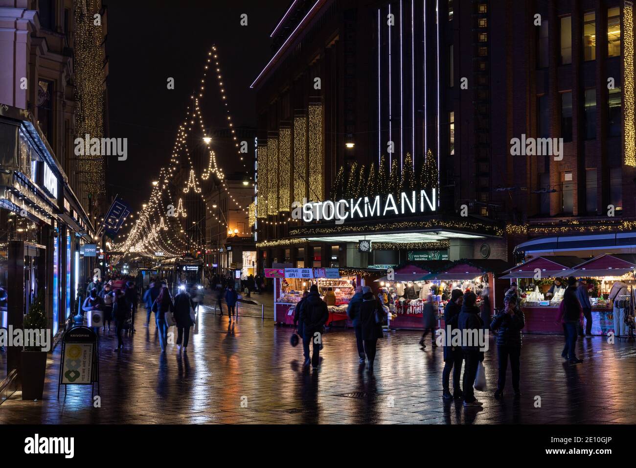 People on Aleksanterinkatu with Christmas lights, Stockmann department store main entrance and some Christmas stalls in Helsinki, Finland Stock Photo