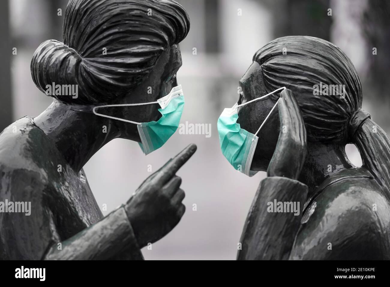 Mouth and nose protection, everyday mask against the corona virus on the sculpture group 'Klönschnack' by the sculptor Fidelis Bentele (1905-1987) in Hanover, Germany, January 3rd, 2021   ---   Mund-Nasenschutz, Alltagsmaske gegen das Corona-Virus an der Skulpturengruppe 'Klönschnack' des Bildhauers Fidelis Bentele (1905-1987) in Hannover, 03.01.2021 Stock Photo