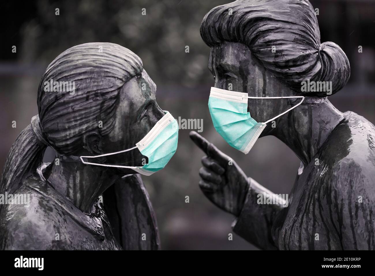 Mouth and nose protection, everyday mask against the corona virus on the sculpture group 'Klönschnack' by the sculptor Fidelis Bentele (1905-1987) in Hanover, Germany, January 3rd, 2021   ---   Mund-Nasenschutz, Alltagsmaske gegen das Corona-Virus an der Skulpturengruppe 'Klönschnack' des Bildhauers Fidelis Bentele (1905-1987) in Hannover, 03.01.2021 Stock Photo