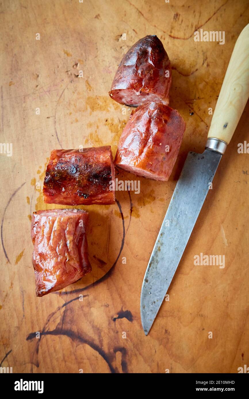 Knife and Sliced Fresh Cooked Sausage on Cutting Board Stock Photo