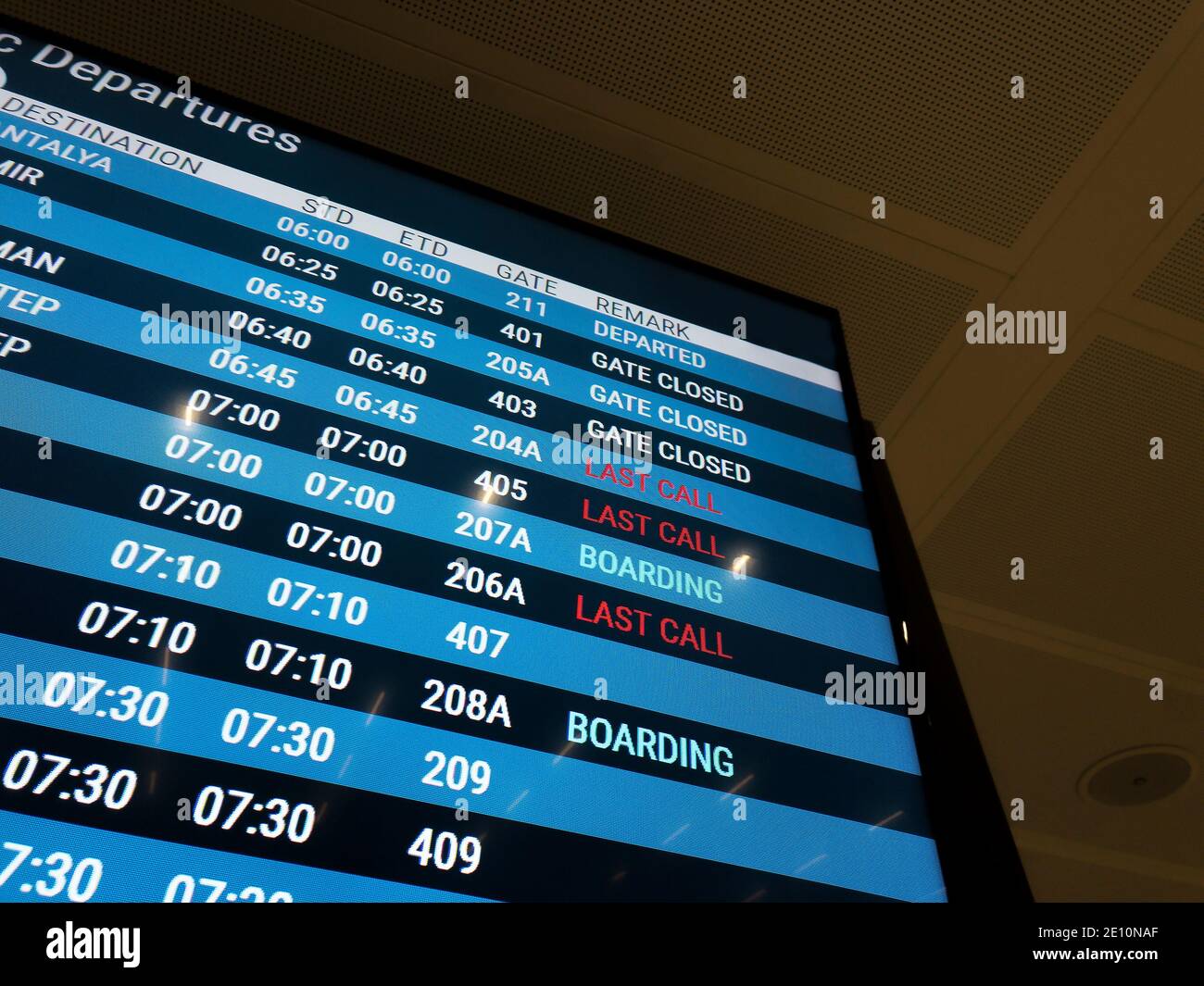 A blue digital screen at an airport announcing time and gate info for each flight. Messages are: LAST CALL, BOARDING and GATE CLOSED Stock Photo