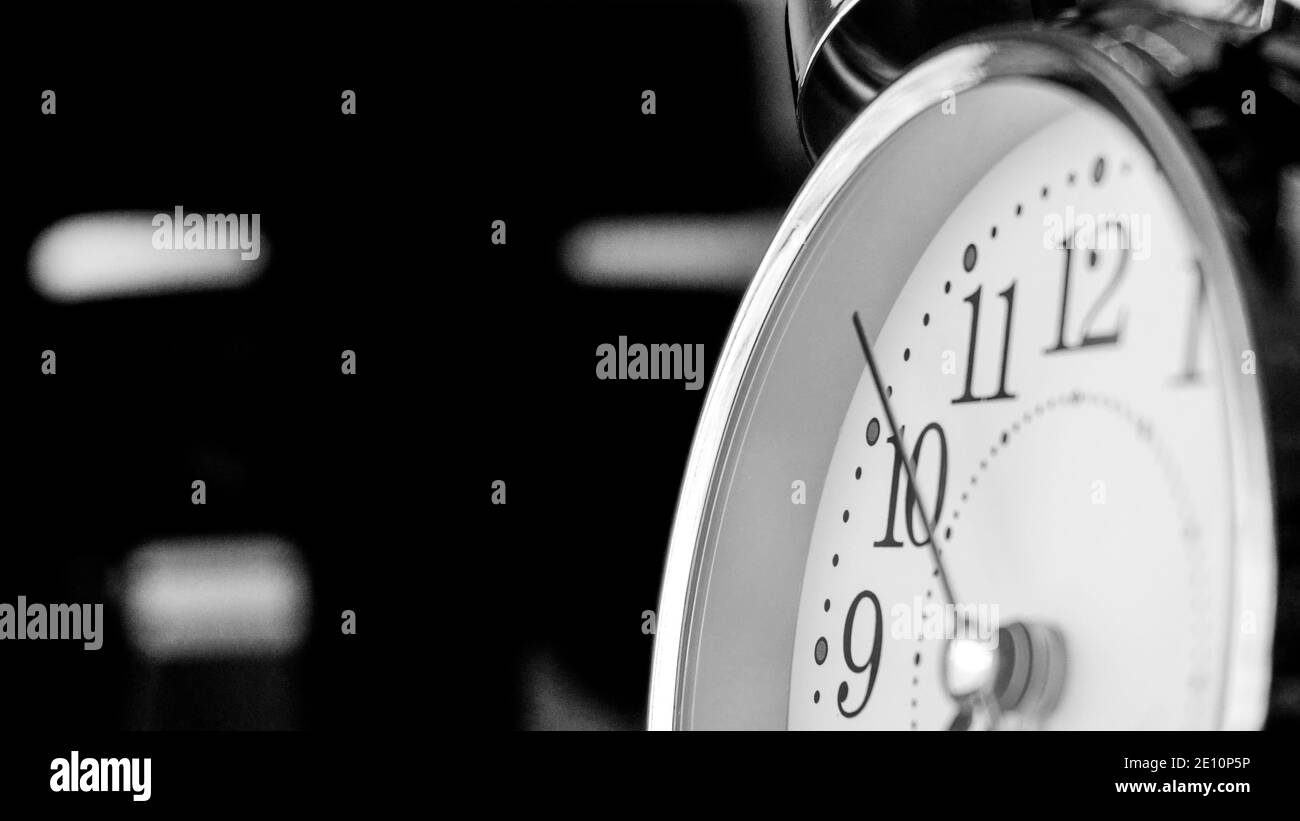 Black white big metallic clock close up. Time or showing time concept. Classic retro mechanical alarm clock with ringer. Time passing or waking up in Stock Photo