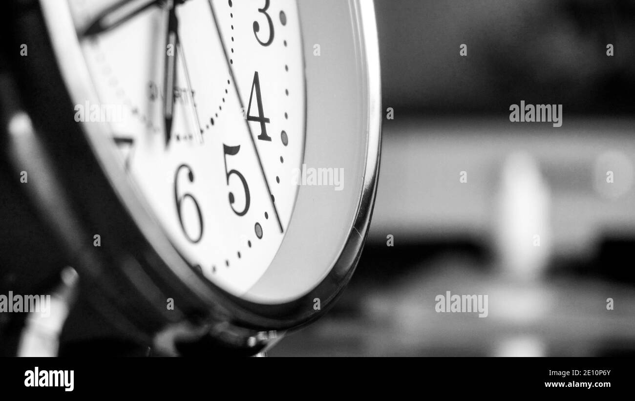 Black white big metallic clock close up. Time or showing time concept. Classic retro mechanical alarm clock with ringer. Time passing or waking up in Stock Photo