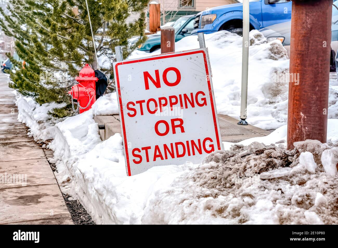 No Stopping or Standing signage on a snowy road side along a pathway in winter Stock Photo