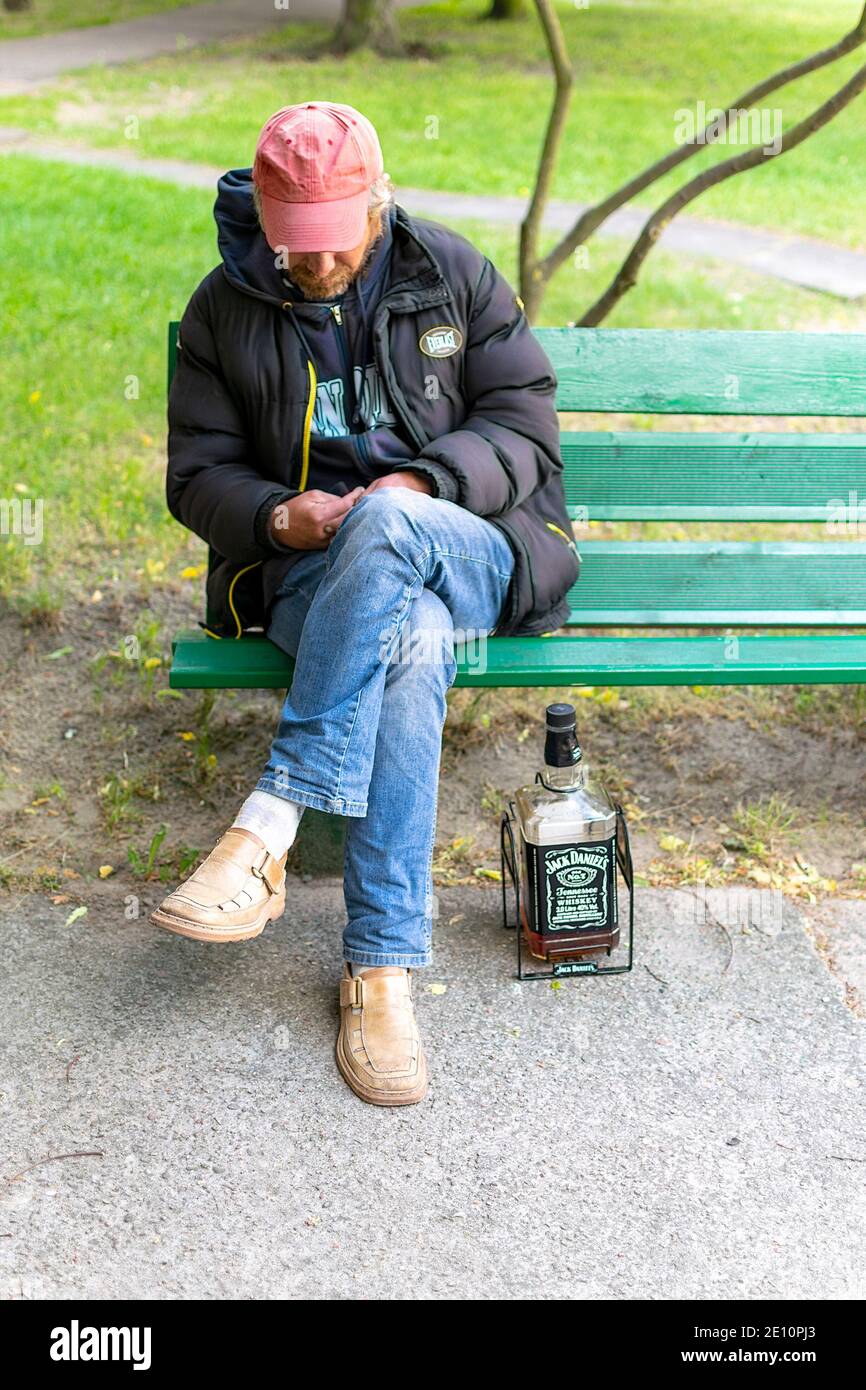 Legionowo, Poland May 18, 2020 Drunk man on a bench with a big