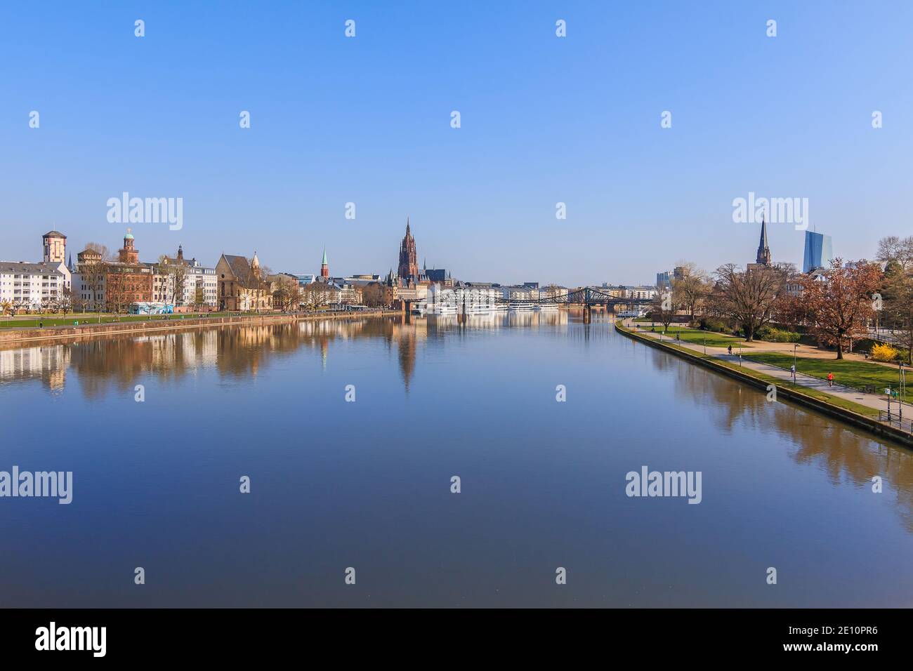 Panorama Frankfurt with the river Main. Park on the banks of the Main with trees and lawns in sunshine and blue sky. Frankfurt Cathedral and buildings Stock Photo