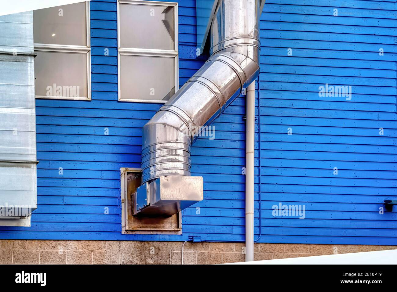 Air conditioning metal ducts viewed outside of home with vibrant blue