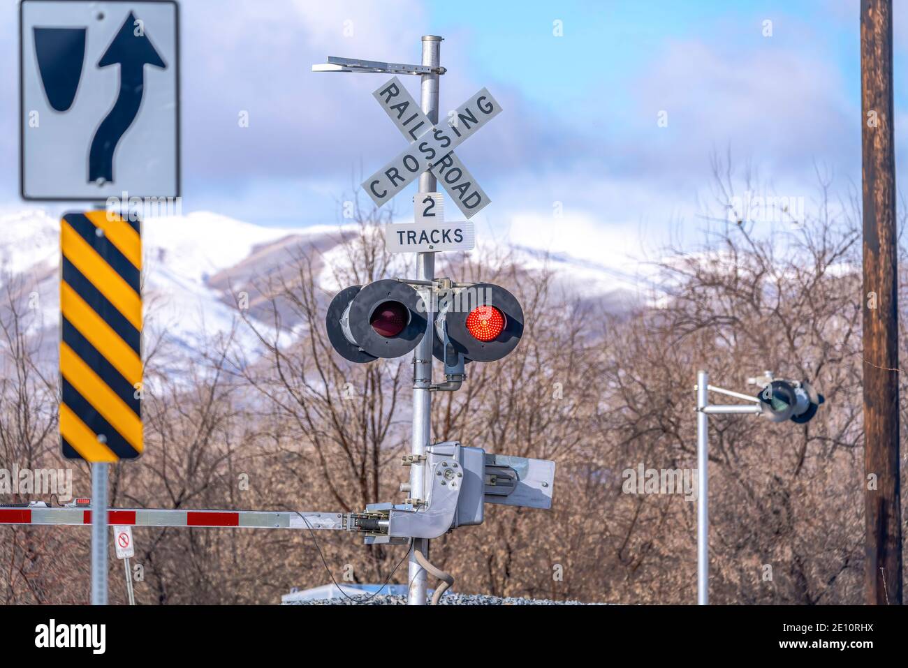 Grade crossing signal with red light gate and crossbuck at railroad ...