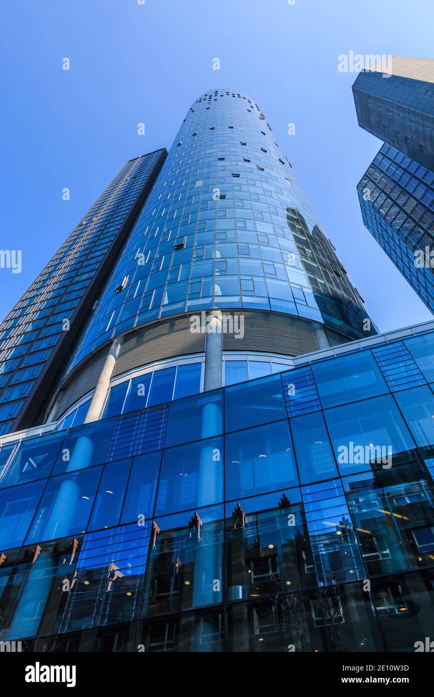 High-rise building with window facade in Frankfurt Main. Light reflections in sunshine and blue skies. Buildings from the financial and business distr Stock Photo