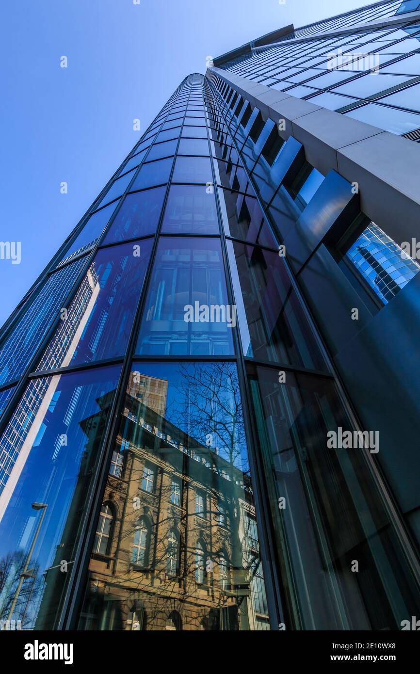Skyscrapers of the city of Frankfurt in sunshine and blue sky. Looking up along the glass front with reflections. Blue window facade on a skyscraper Stock Photo