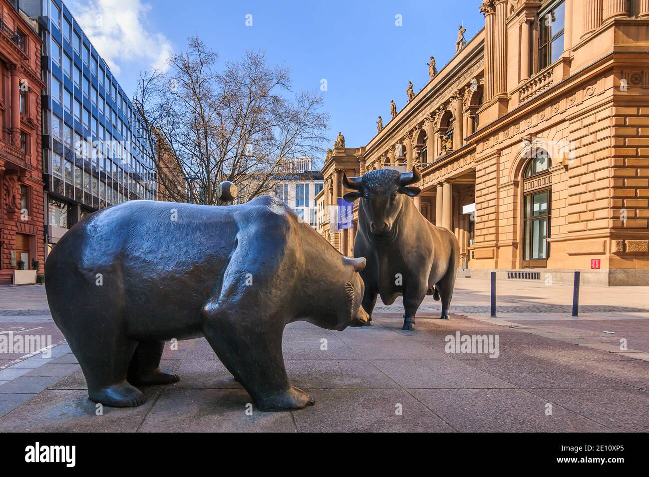 Bull and bear as a symbol figure. Place in front of the building of the Frankfurt Stock Exchange. Commercial buildings with a brown facade in the suns Stock Photo