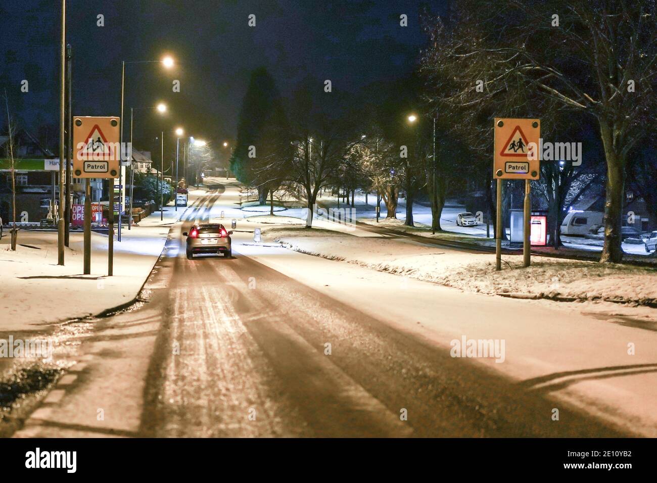 Kidderminster, UK. 2nd January, 2021. UK weather: with daytime temperatures failing to rise much above freezing across Worcestshire and roads already icy, Kidderminster is hit with yet more snow showers. Little traffic can be seen on the snow-covered roads at night.  Credit: Lee Hudson Stock Photo