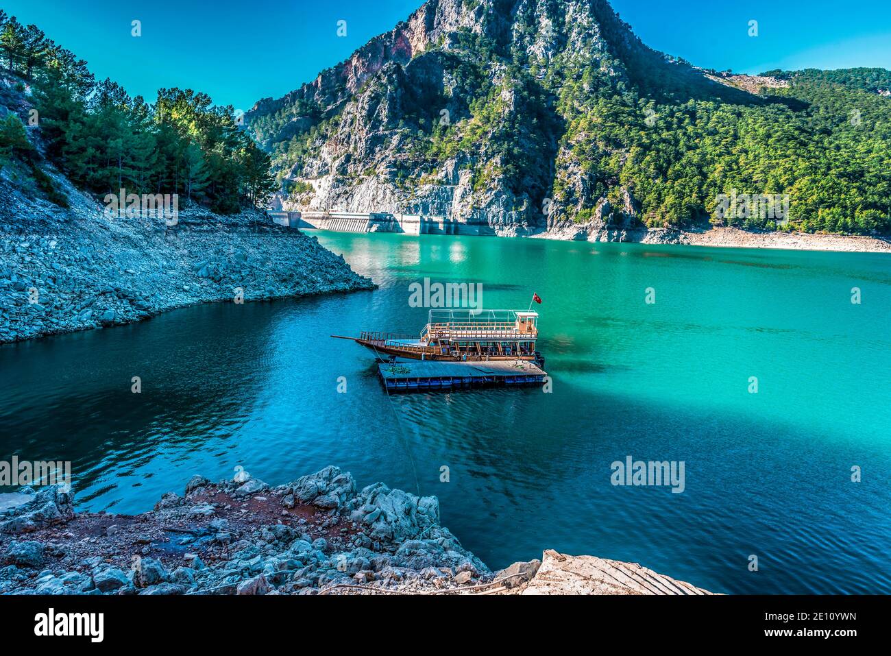 Ship standing in the middle of a blue lake, Green canyon, Turkey Stock Photo