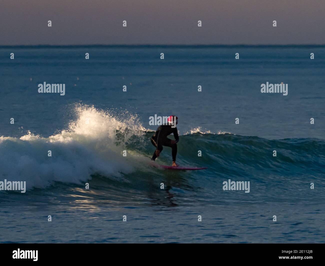 Santa surfing the waves off Mission Beach, San Diego, California at Christmas Stock Photo