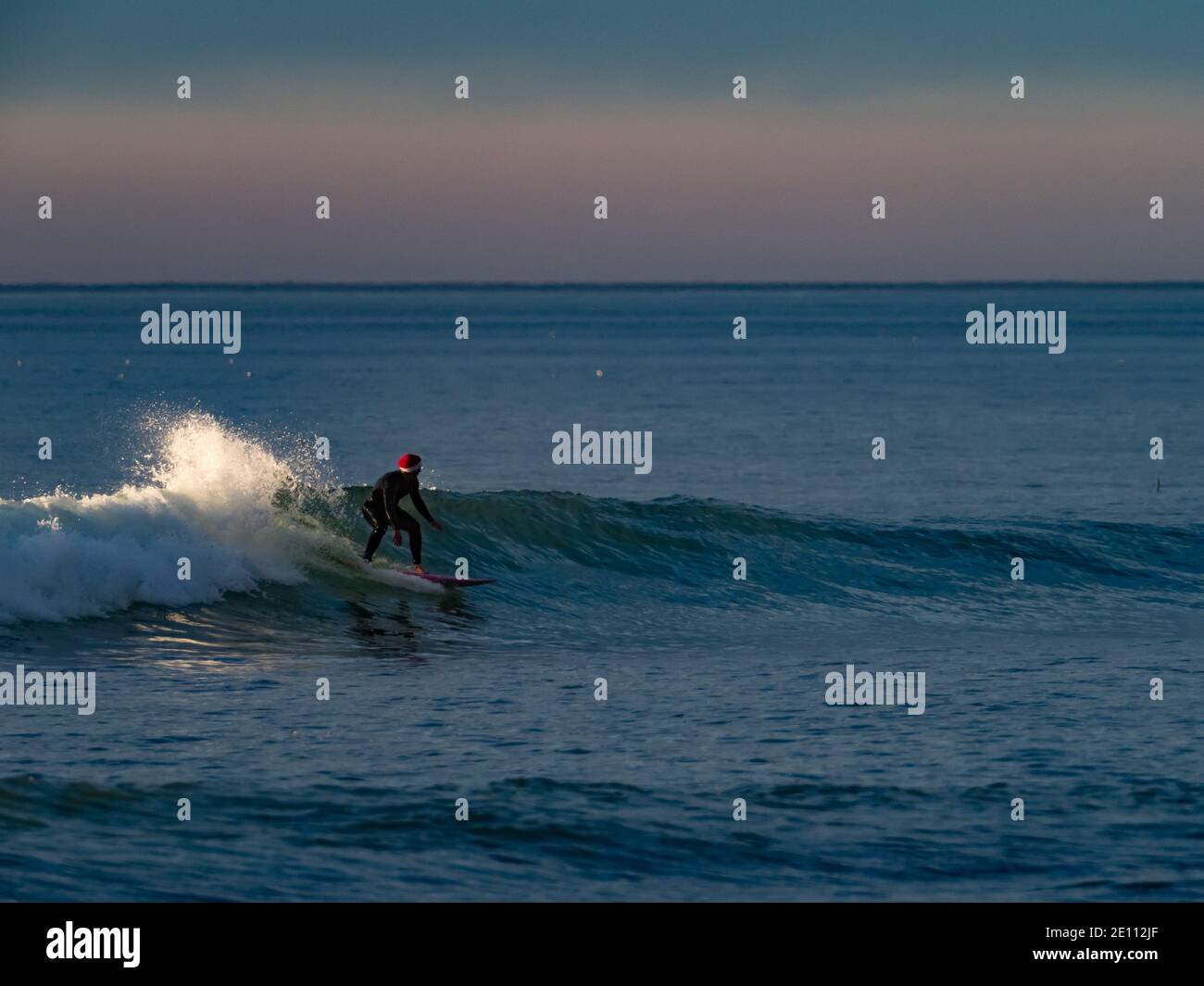Santa surfing the waves off Mission Beach, San Diego, California at Christmas Stock Photo