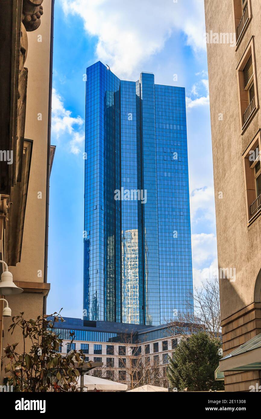 Skyscraper with glass facade in Frankfurt in sunshine with blue sky and clouds. View between two skyscrapers. Office and commercial buildings with ref Stock Photo