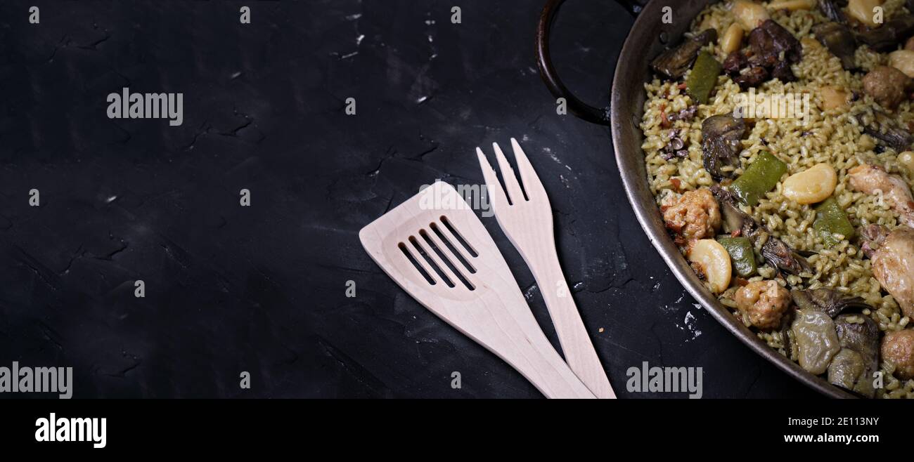traditional spanish dish of paella valenciana with typical wooden