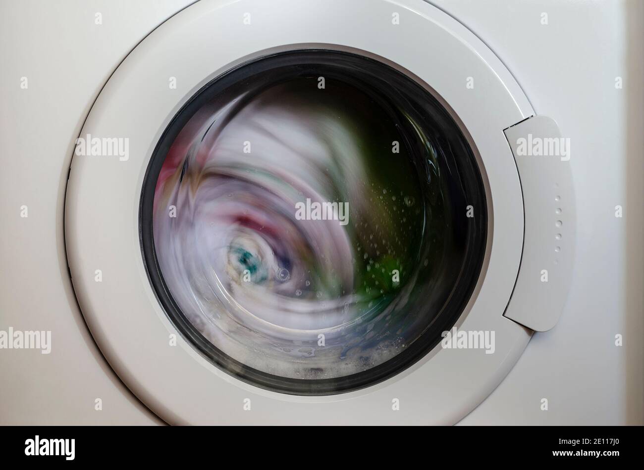 Washing machine door with rotating garments inside Stock Photo Alamy