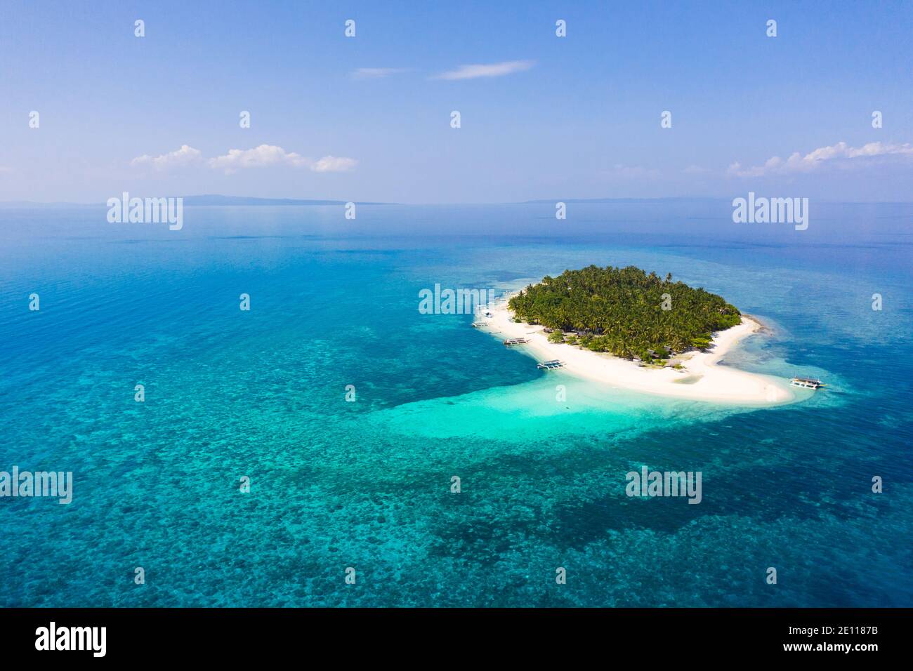 Tropical island on a coral reef, top view. Island with a tropical beach and turquoise lagoons. White sand beach with coconut trees, top view. Digyo Is Stock Photo
