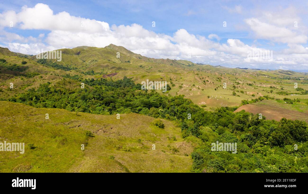 Beautiful landscape on the island of Luzon, aerial view. Hills and mountains are covered with meadows and grass. Stock Photo