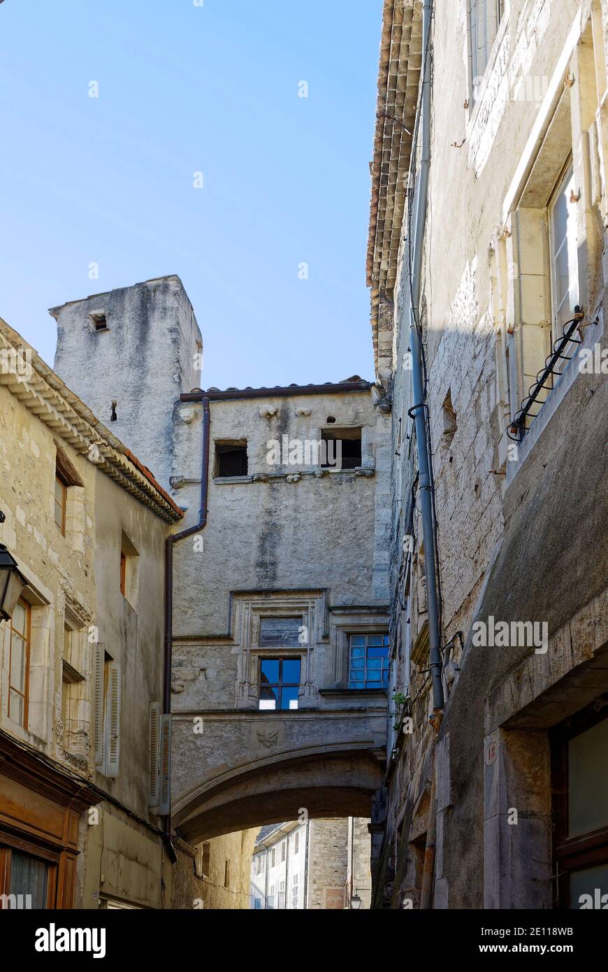2 old buildings, connected with arched structure, architecture, narrow street, Europe, Viviers, France; summer Stock Photo