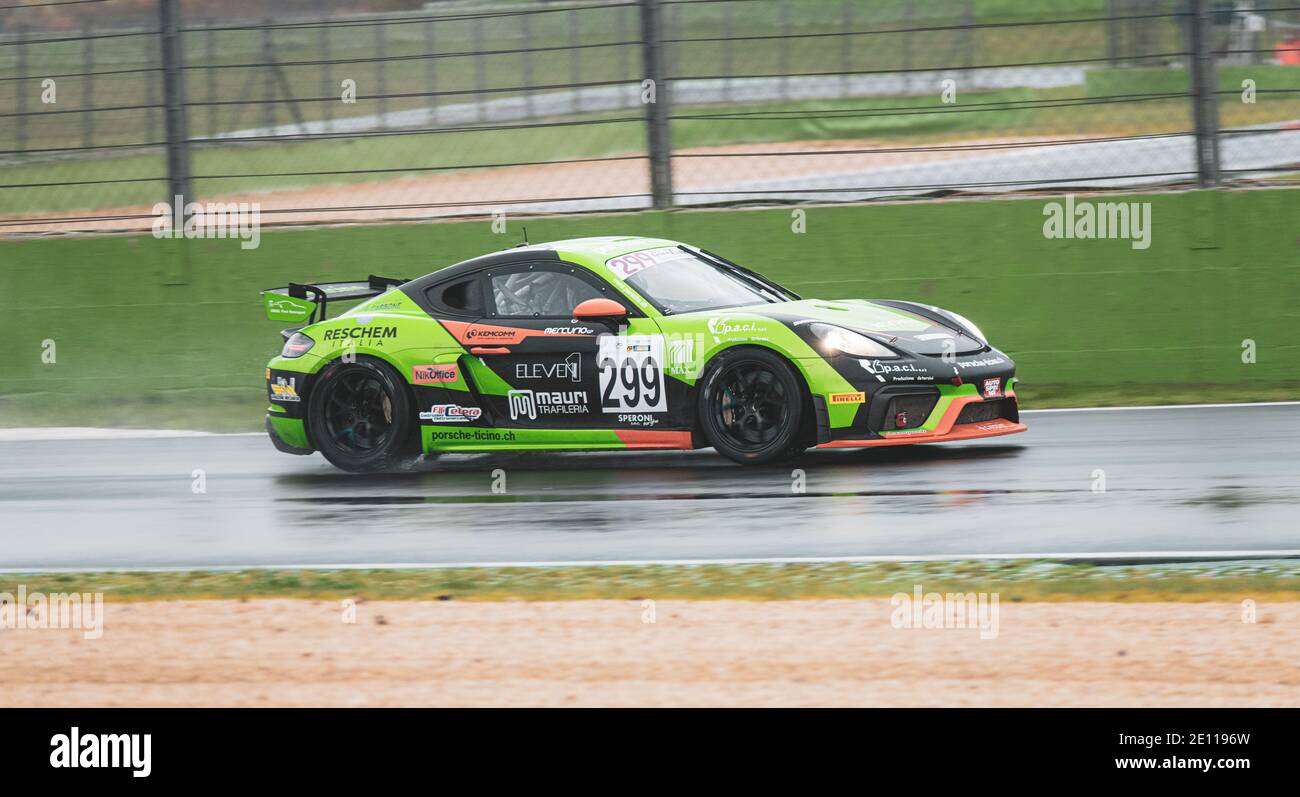 Supercar Porsche GT racing action on wet raining asphalt track circuit spraying water Stock Photo