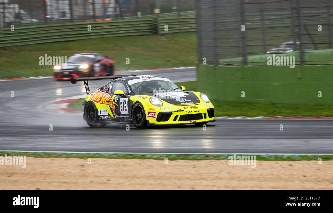 Supercar Porsche racing action on wet raining asphalt track circuit spraying water Stock Photo