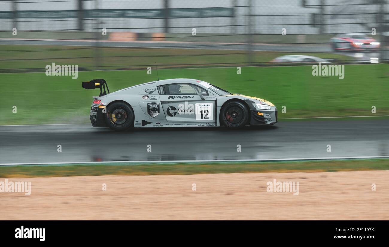 Supercar Audi racing action on wet raining asphalt track circuit spraying water Stock Photo