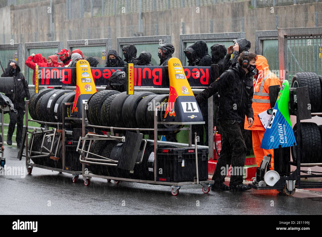 Vallelunga, Italy 6 december 2020, Aci racing weekend. Red Bull racing motorsport car team people with tire set and car nose change parts mechanics un Stock Photo