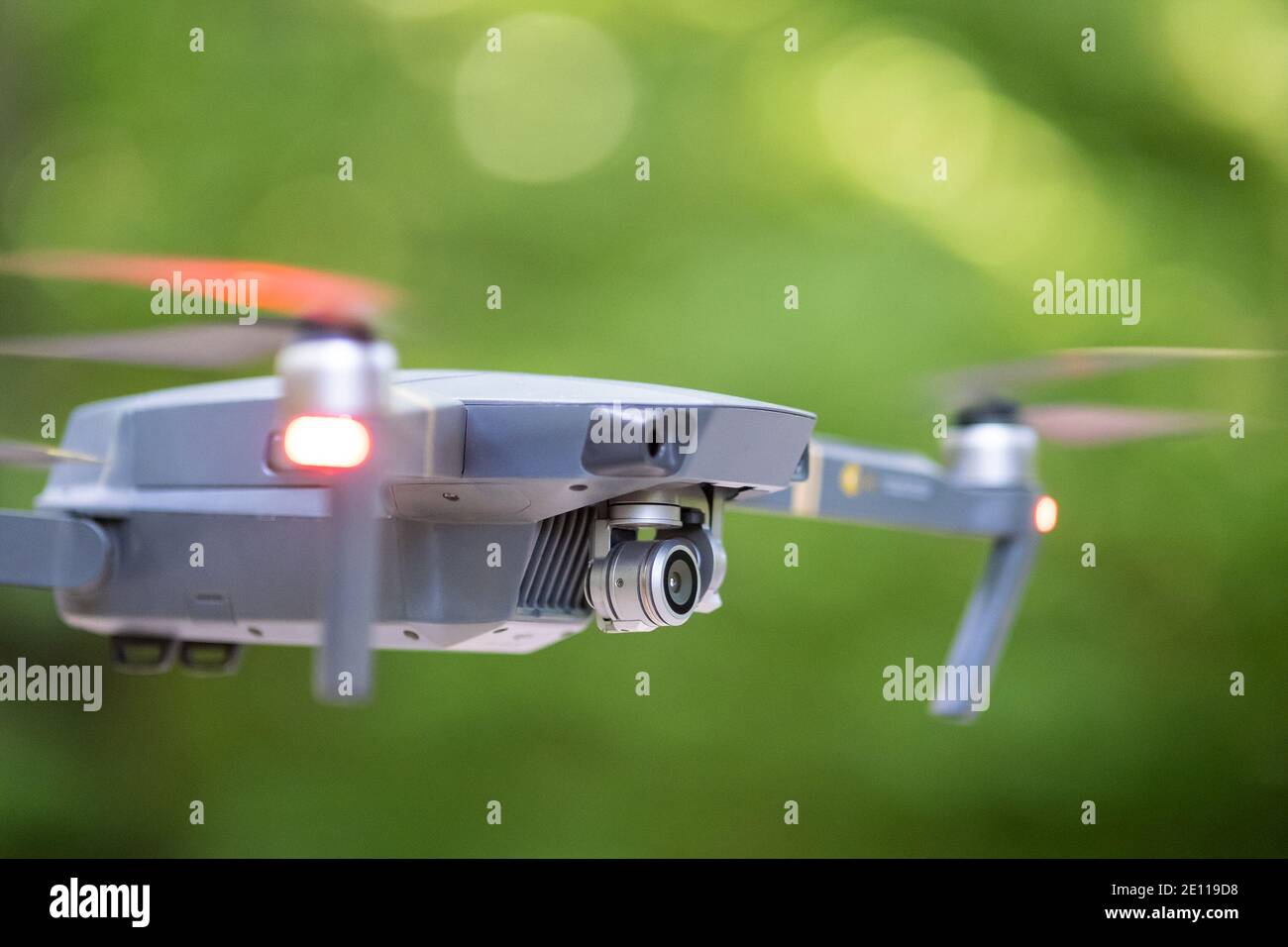 Drone copter with blurred propellers and video camera flying in air ...