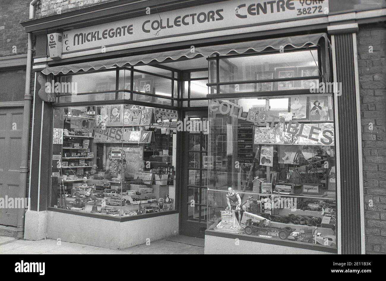 1980s, shop window of a high-street retail store, traditional in style with a central doorway, selling collectable items such as train sets, toy cars, figures and stamps, Micklegate Street, York, Egland, UK. Stock Photo