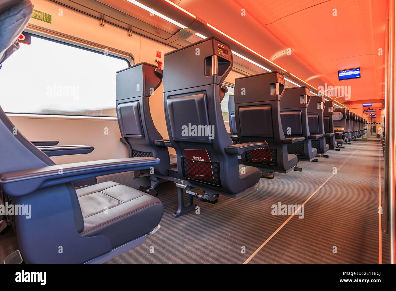 Interior of a train compartment of the german railway during the journey. Empty seats in first class. Double seats with window and central aisle. View Stock Photo