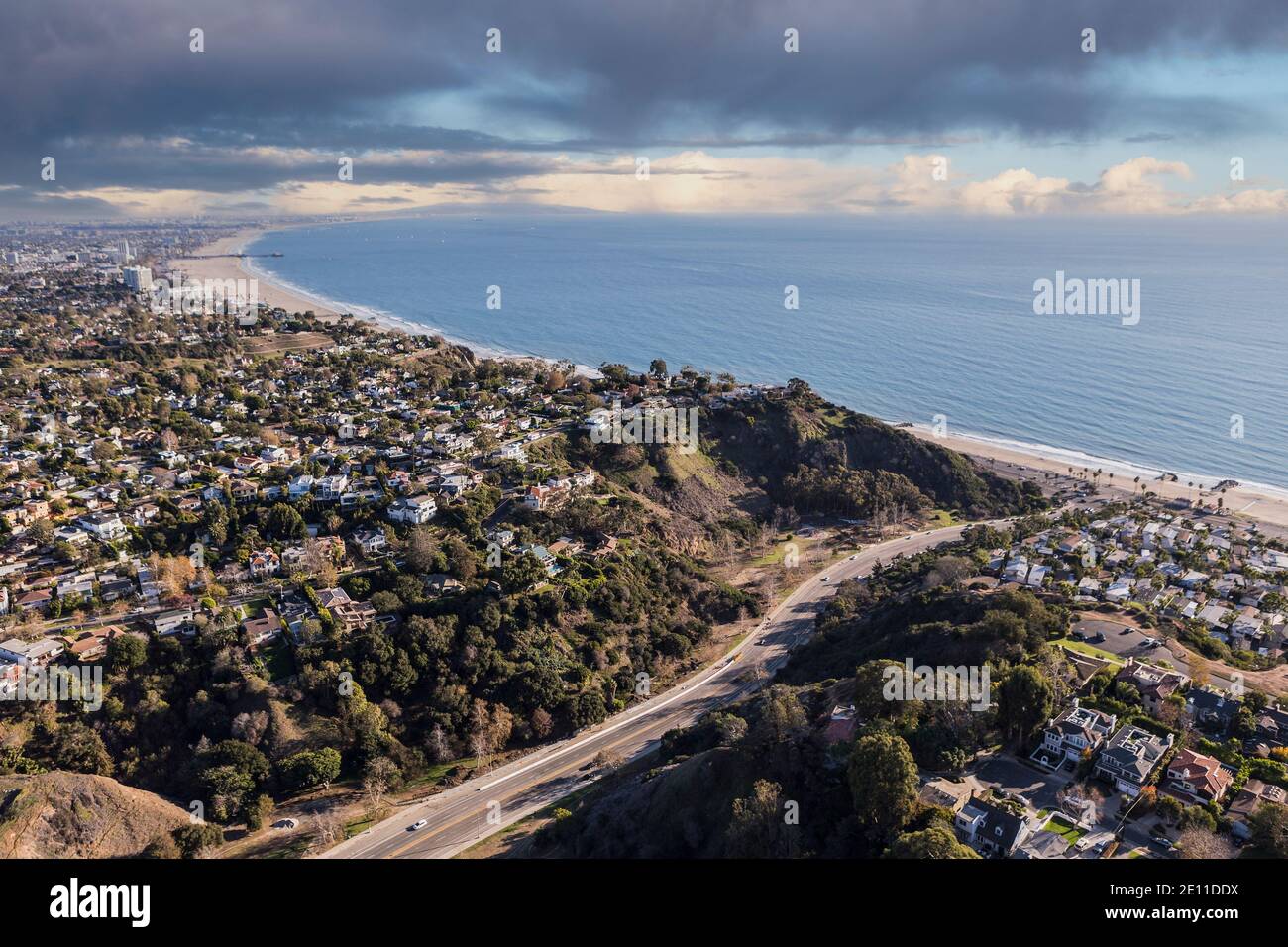 Aerial of Temescal Canyon Road and Pacific Palisades neighborhoods with stormy sky near Santa Monica Bay in Southern California. Stock Photo