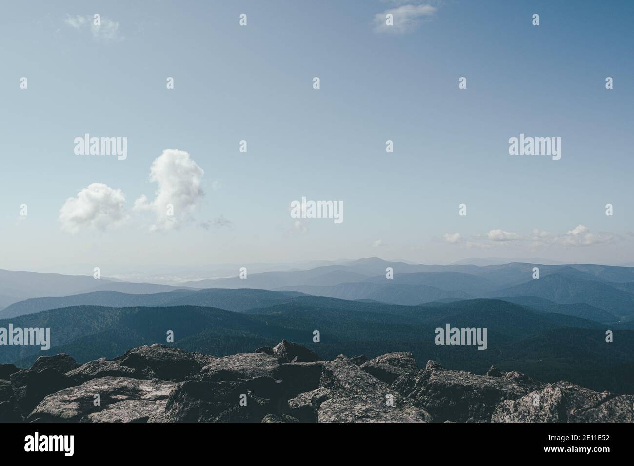 Thick clouds over mountain range, hills in blue haze Stock Photo
