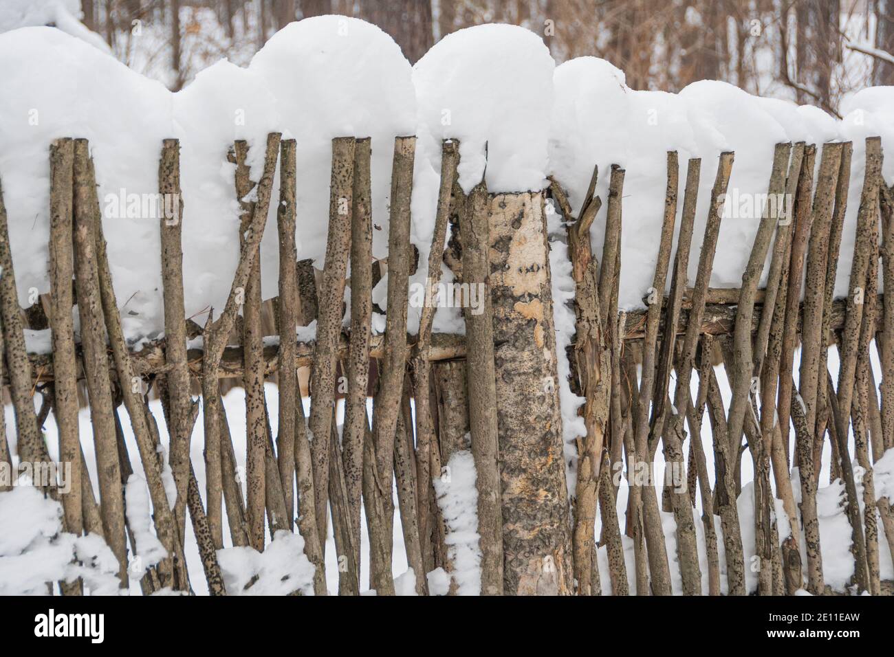 Old wooden village fence made of branches under snow Stock Photo - Alamy