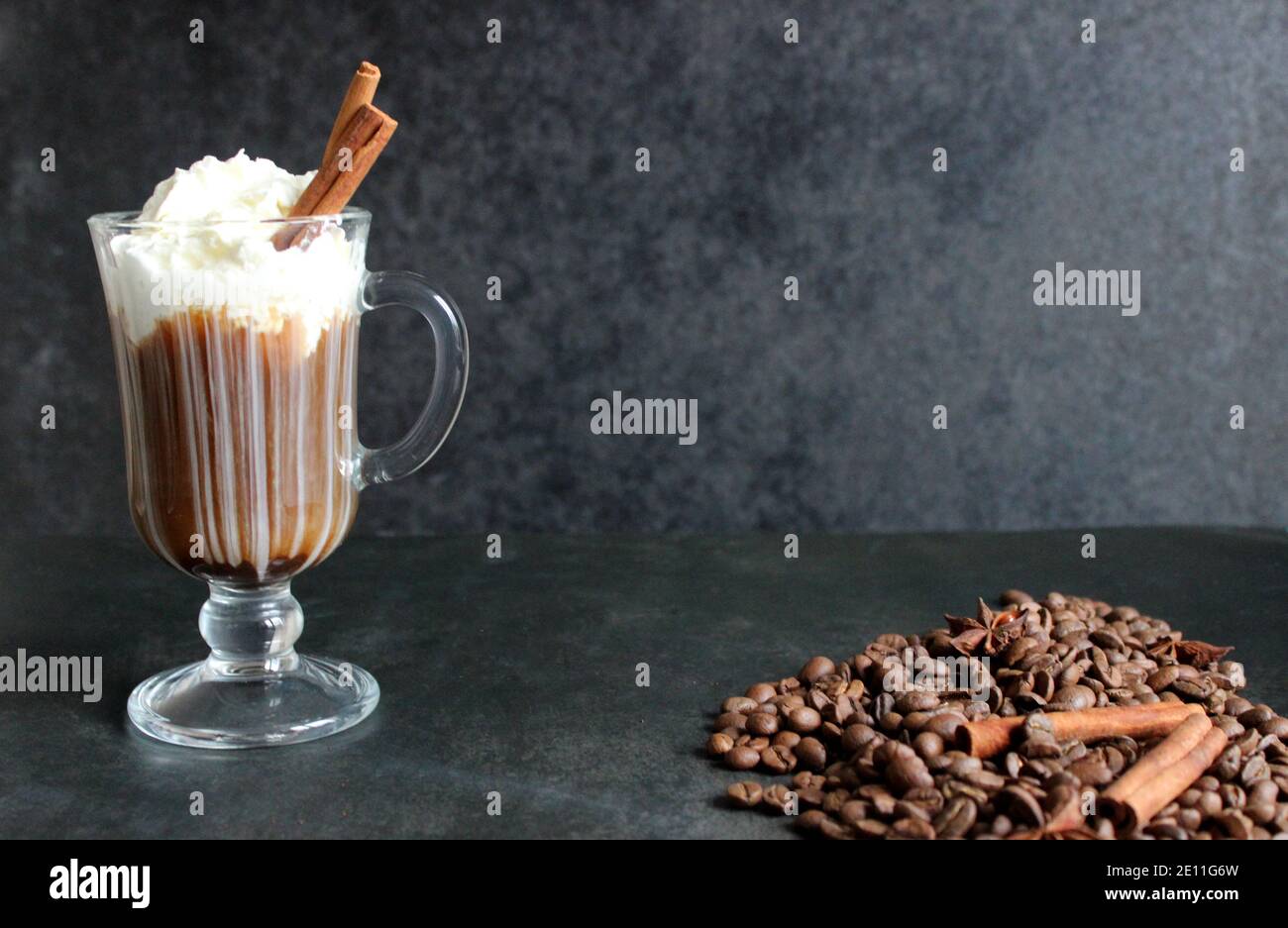 frothy coffee drink. Cappuccino or latte in a transparent glass on a dark background Stock Photo
